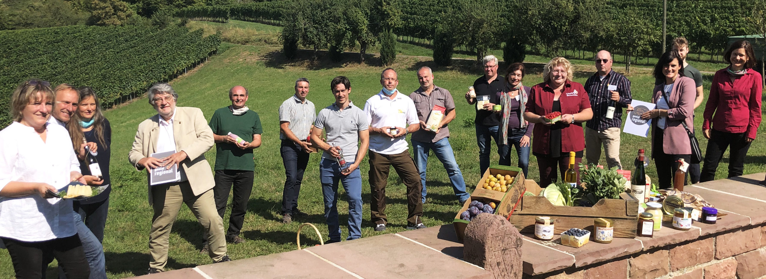 Gründungsmitglieder stehen mit ihren Produkten auf einer Wiese