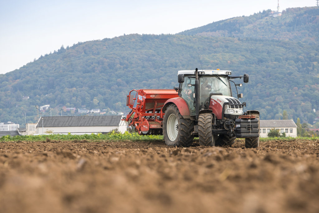 Traktor fährt auf Acker